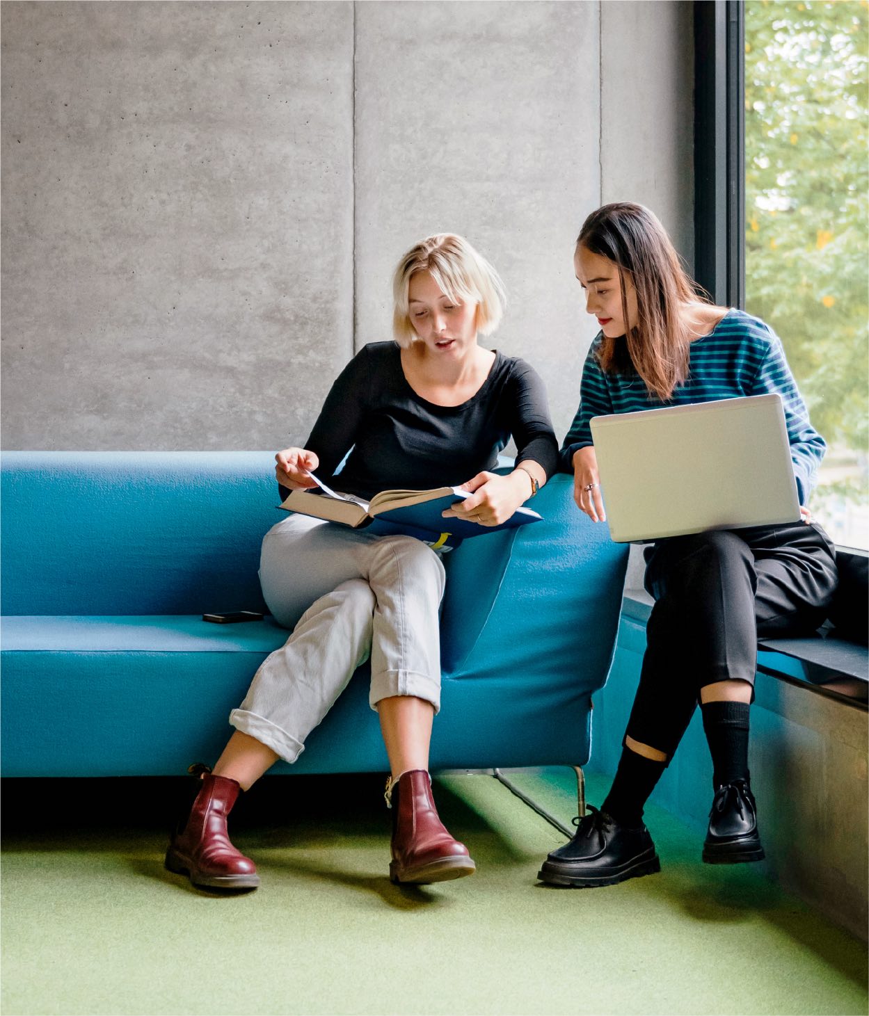 Two women in an office break room working on a project.